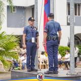 Mga pulis na nakatayo nang tuwid habang nagaganap ang flag raising ceremony sa Naic Municipal Hall