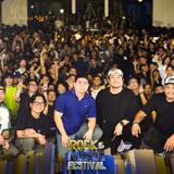 Mga tao sa Naic Rock & Music Festival 2025 sa Naic Town Plaza, may mga nagpo-pose at nagtataas ng kamay