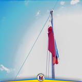 Watawat na itinataas sa poste sa ilalim ng maaliwalas na langit, bahagi ng flag raising ceremony sa Naic